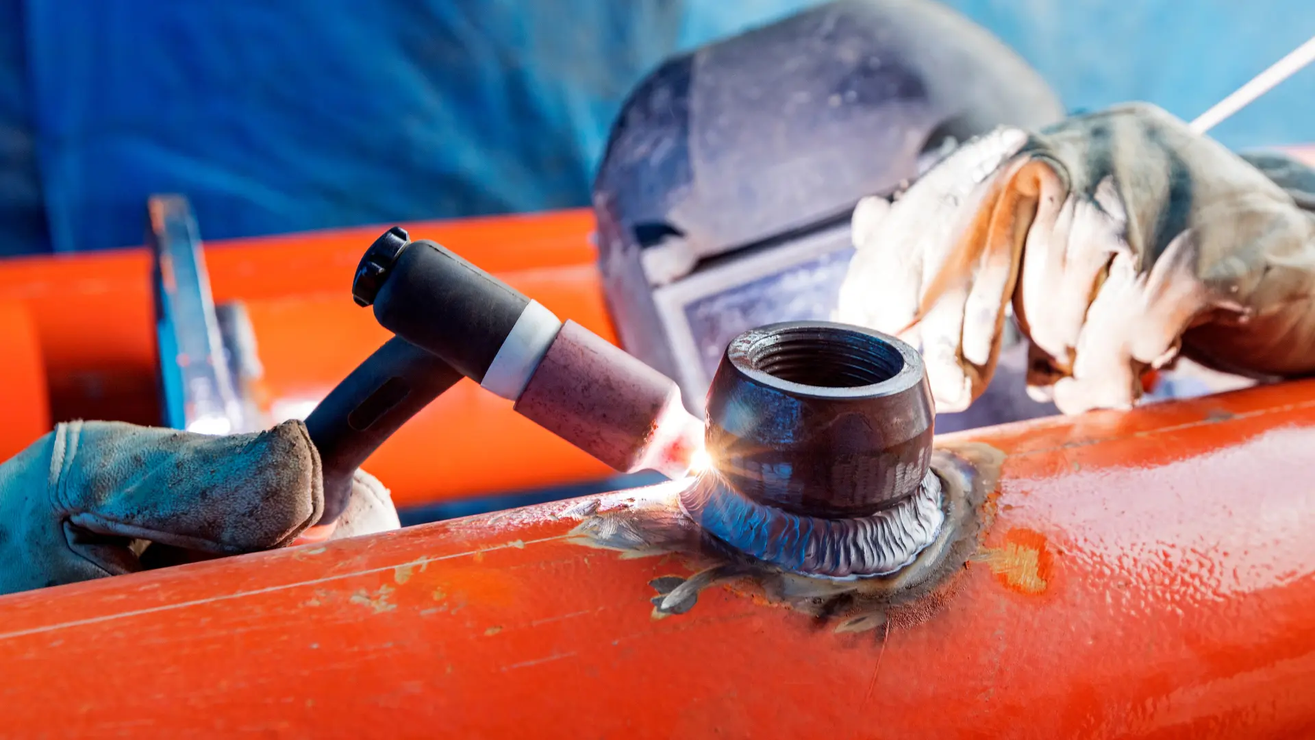 Close-up of welder performing pipe welding for industrial piping works